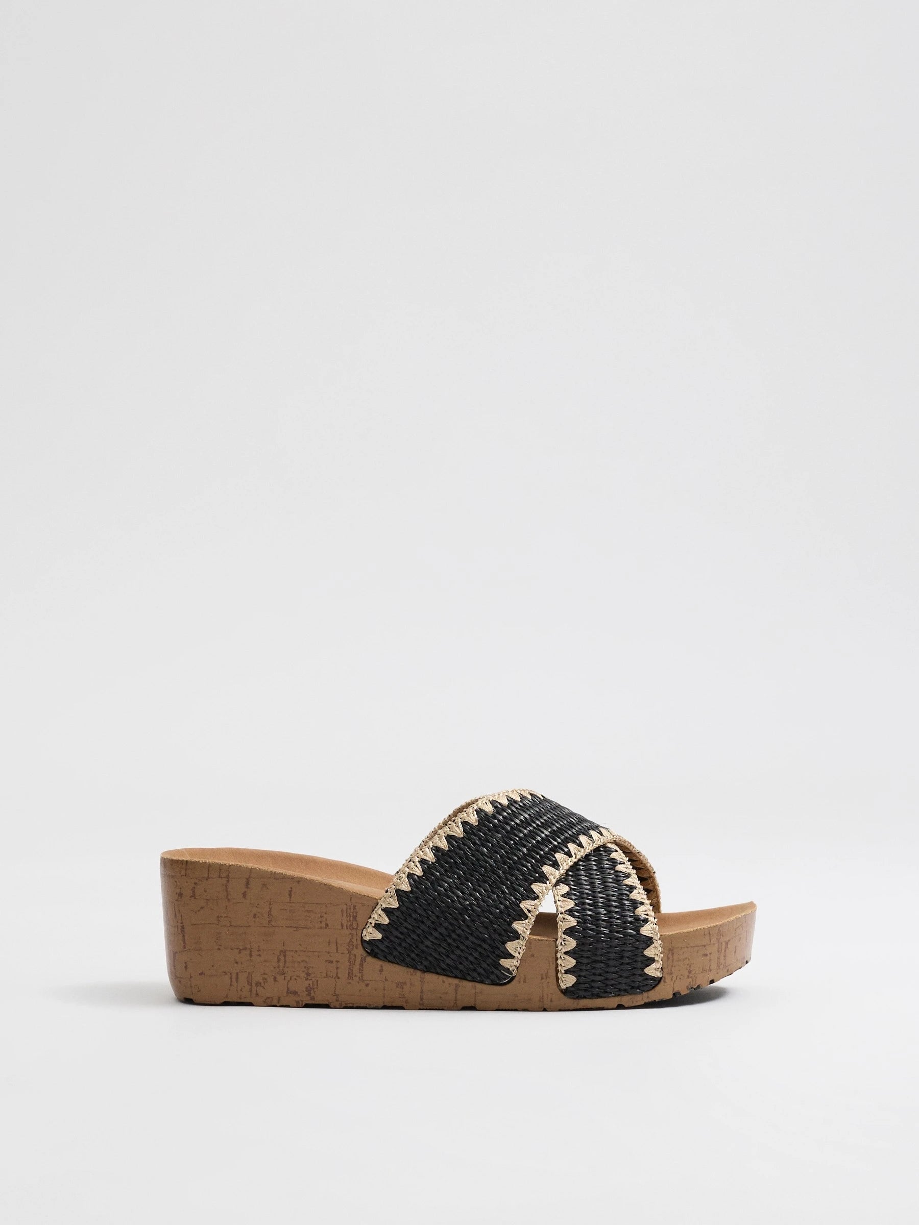 Wedges with black raffia crossed straps, zigzag stitching and cork base for comfort and craft style inside