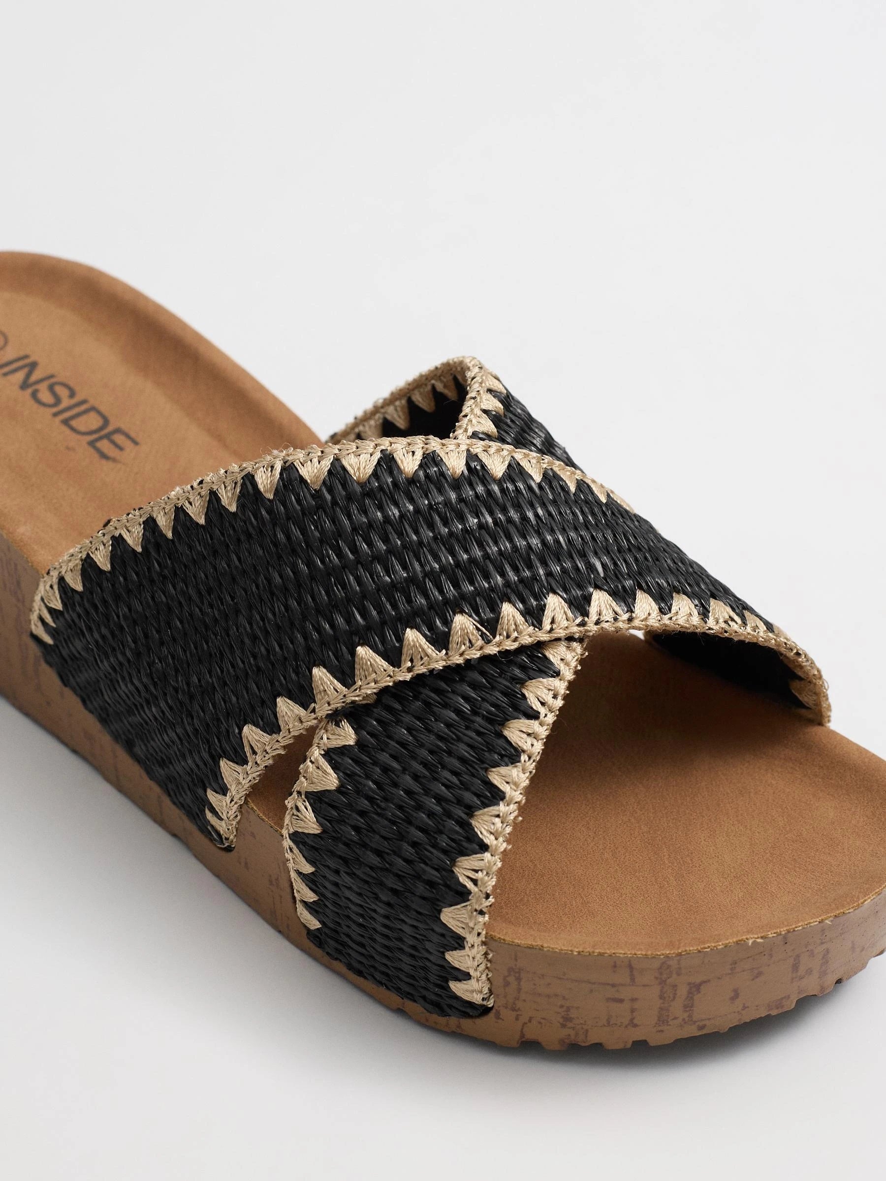 Wedges with black raffia crossed straps, zigzag stitching and cork base for comfort and craft style inside