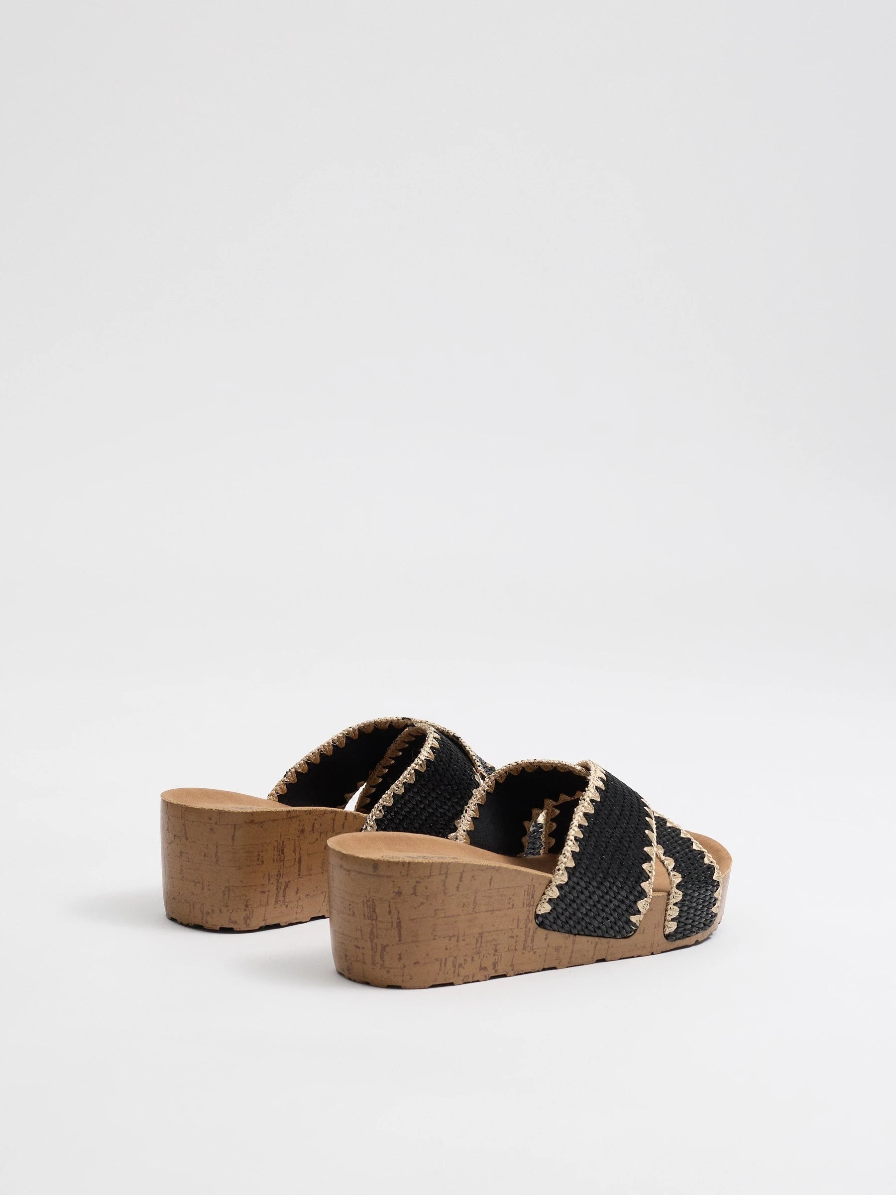 Wedges with black raffia crossed straps, zigzag stitching and cork base for comfort and craft style inside